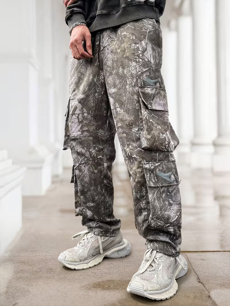 Pantalón cargo de camuflaje gris para hombre en tallas grandes, vista frontal con bolsillos laterales con solapas.
