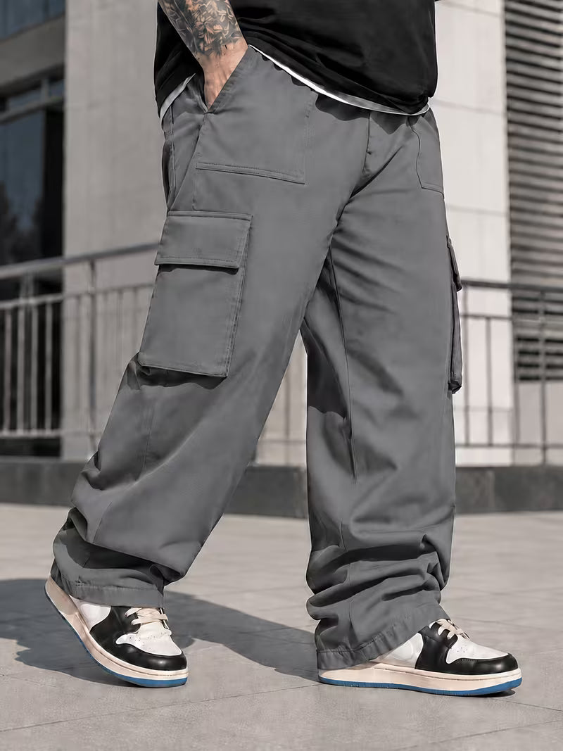 Pantalón cargo gris oscuro para hombre en tallas grandes, vista lateral de bolsillos con solapas.
